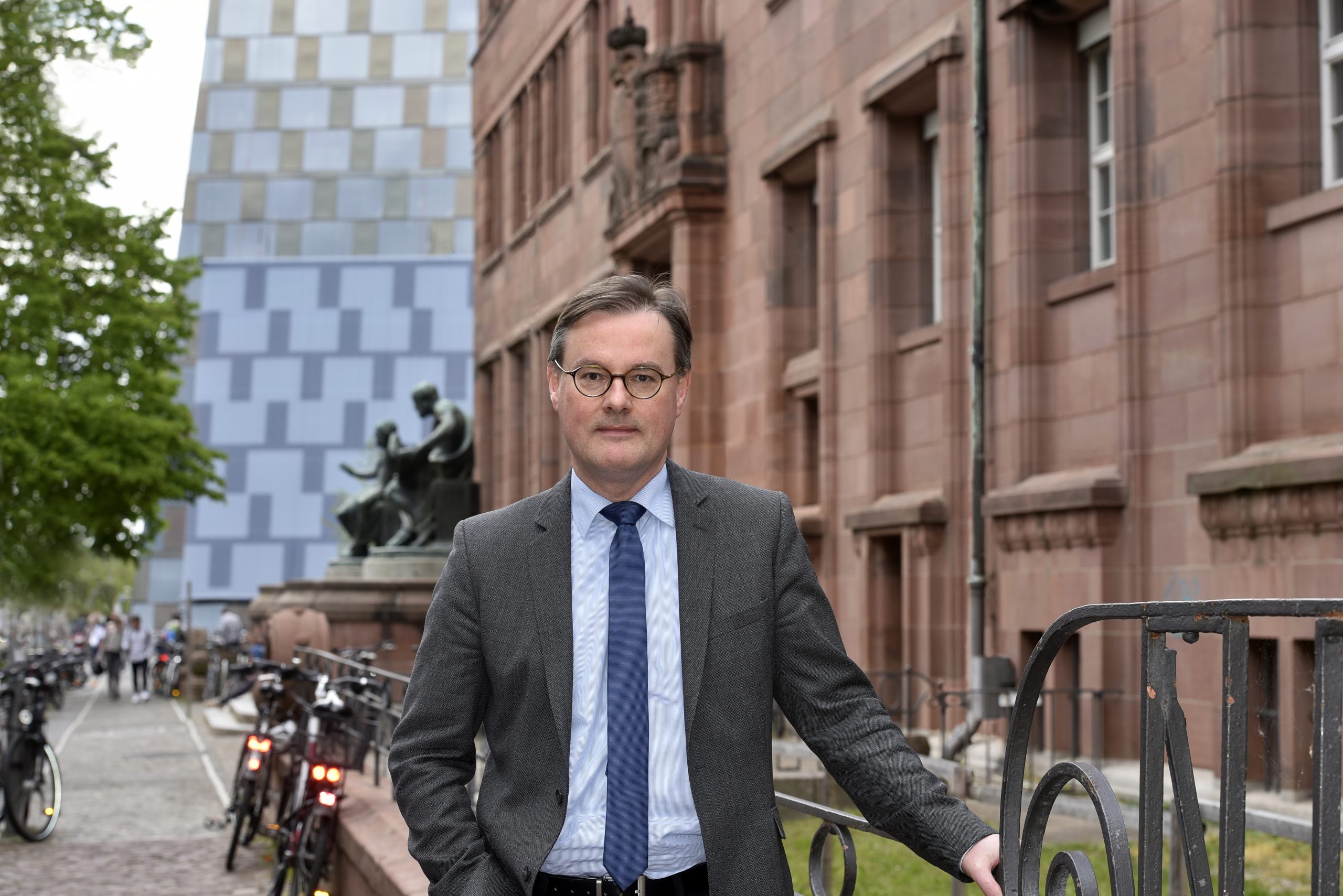 Jörn Leonhard im Anzug vor dem KGI und der Universitätsbibliothek.