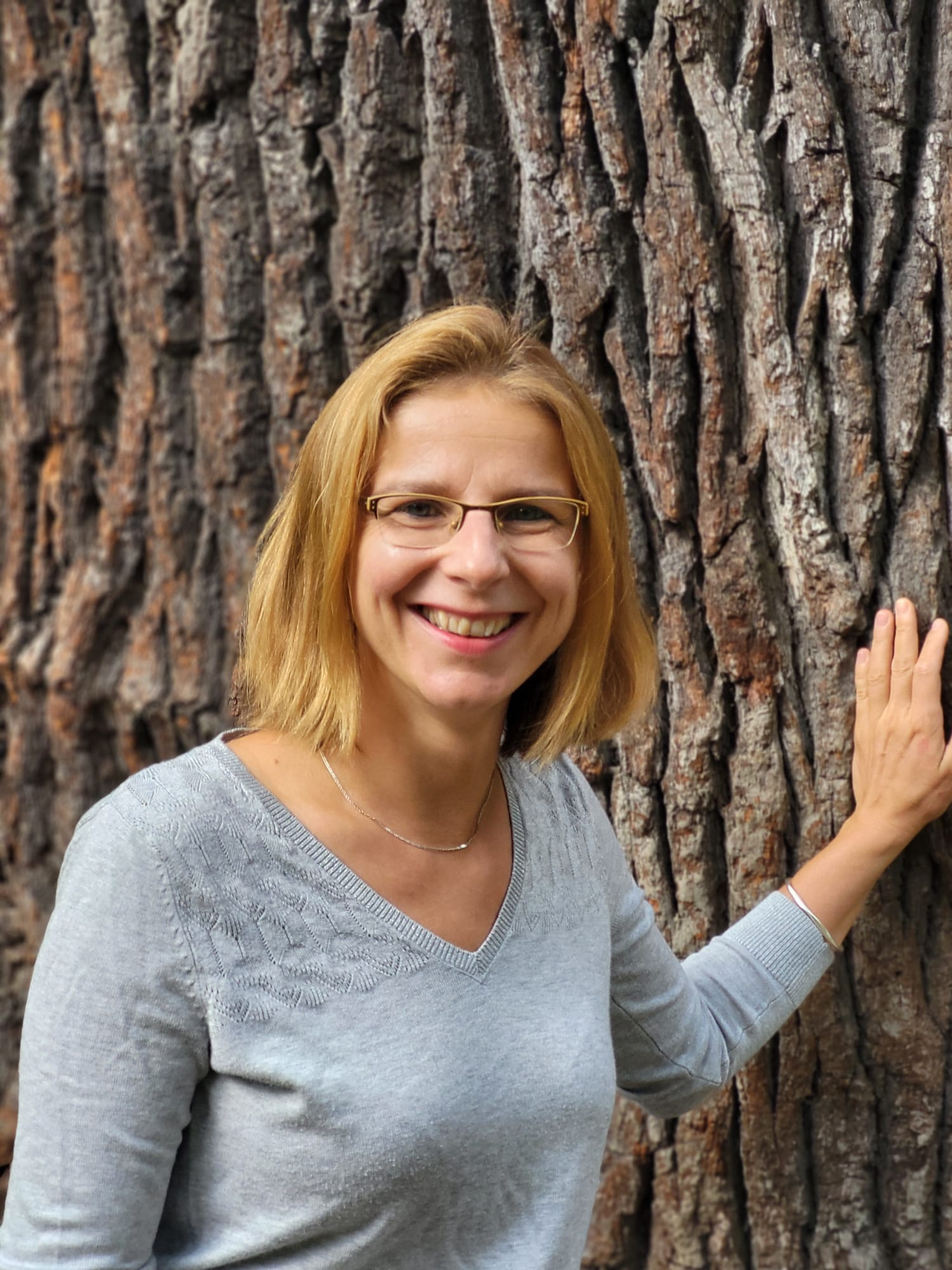 A portrait of Dr. Andrea Seim in front of a tree.