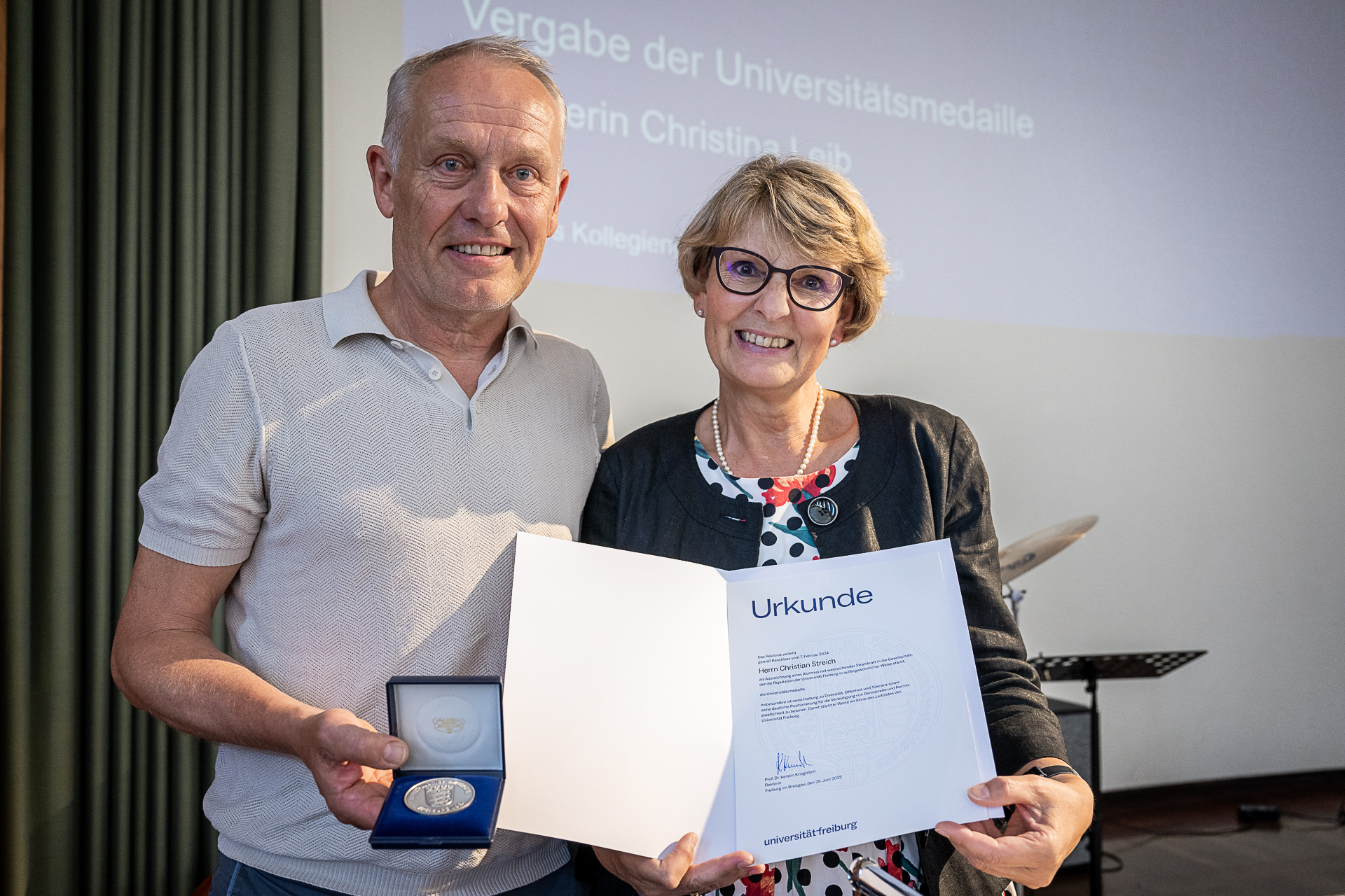 Two people presenting a certificate.