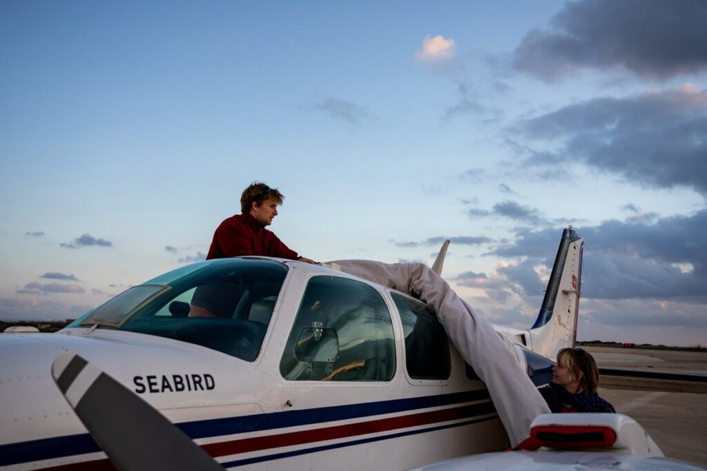 Joseph Oertel stands behind an airplane.