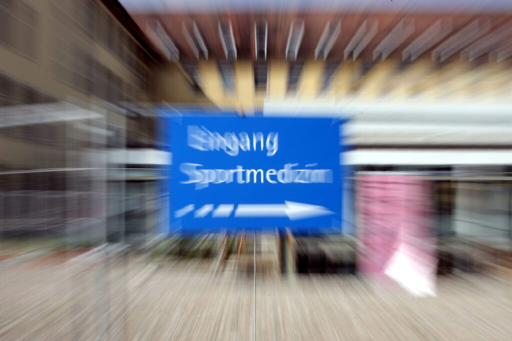 Schild Sportmedizin fotografisch verzerrt.