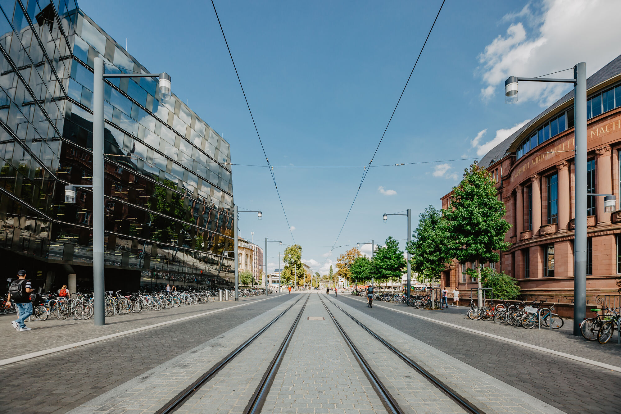 View of the Freiburg University Library on the right and the Kollegiengebäude 1 on the left. The tram tracks form the vanishing point in the centre.