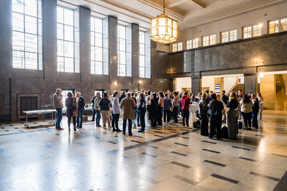 A group of people gathering in an old and venerable hall.