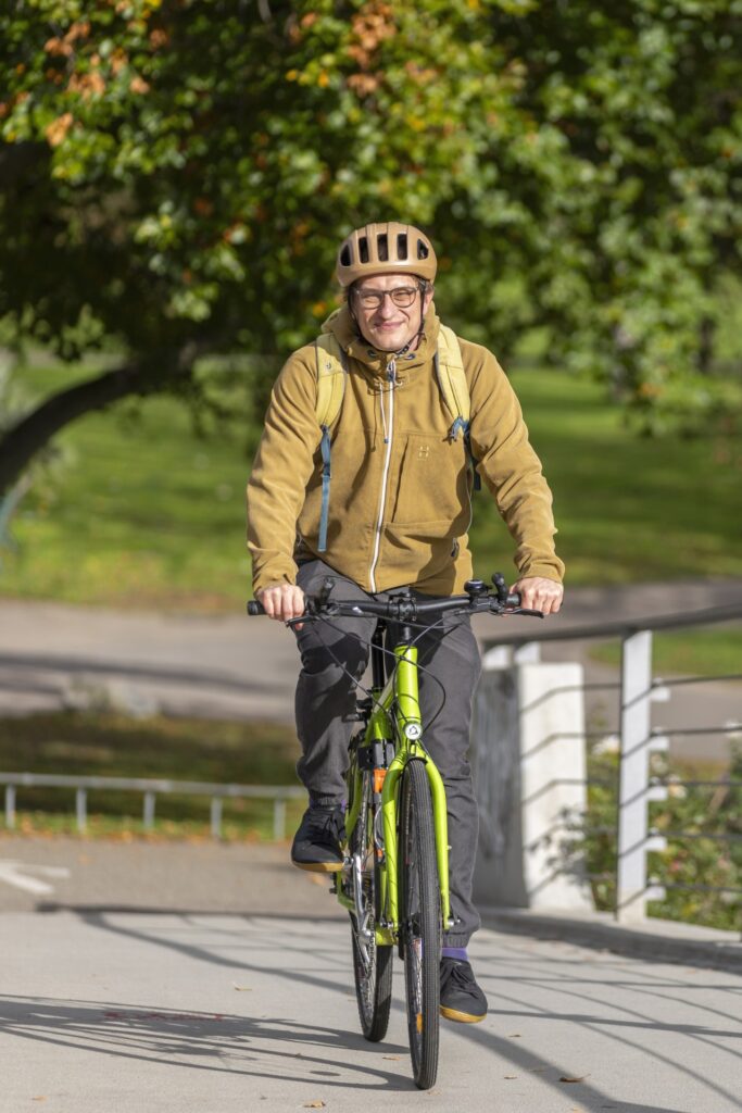 Photo of Joscha Hoffmann, Sustainability Manager of the University of Freiburg, riding a bicycle.