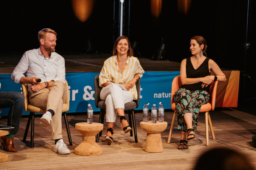 Käpsele Innovations Festival 2024: Three people sit on chairs on a stage and talk to each other