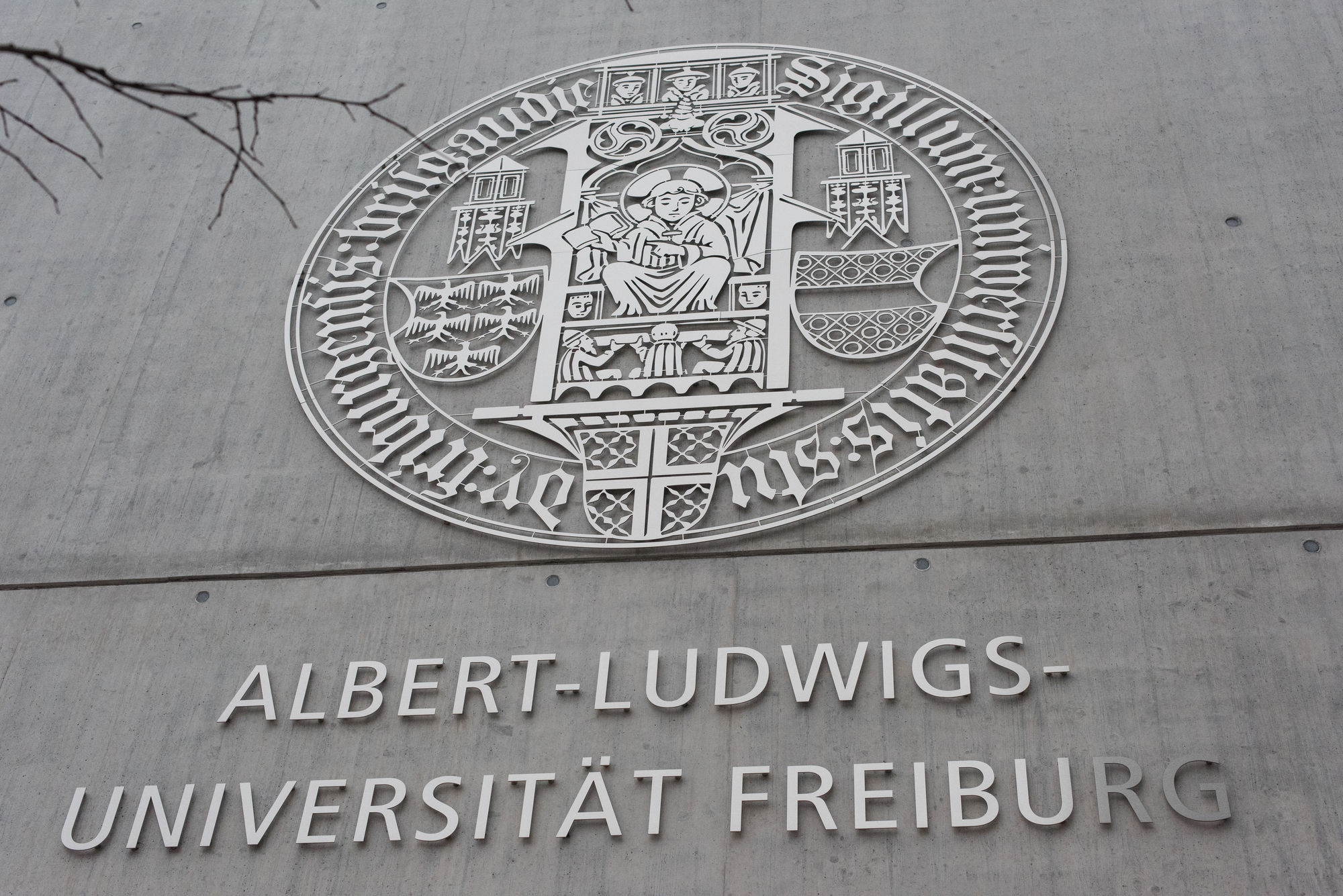 Seal of the University of Freiburg on a wall.