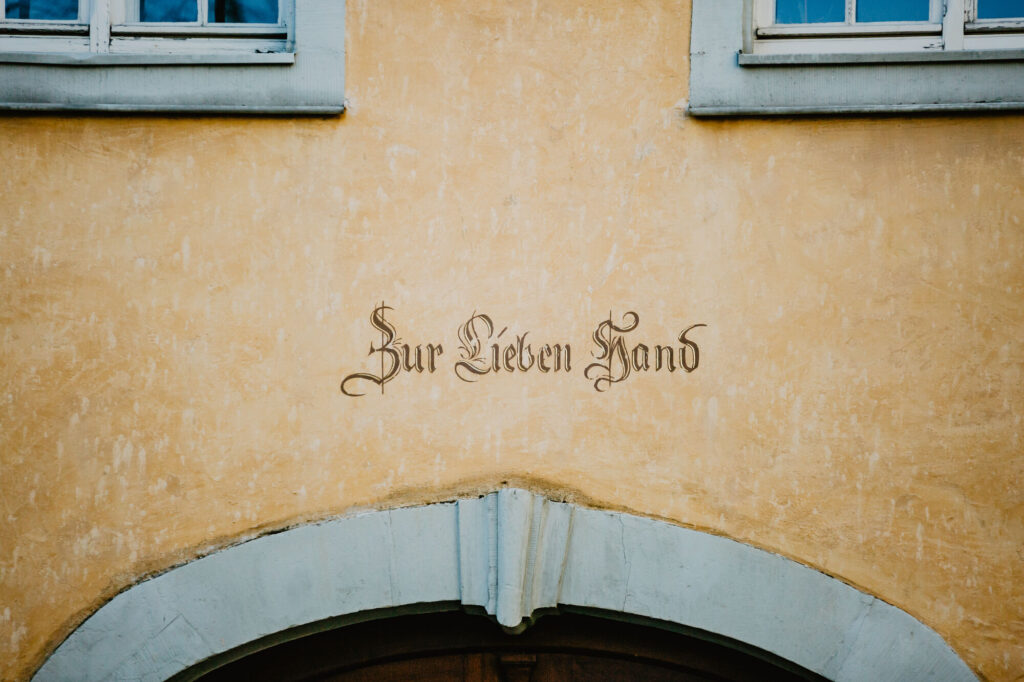 Schriftzug "Zur lieben Hand" über der Tür des Gebäudes "Zur lieben Hand".