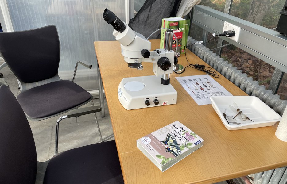 A desk with microscope and identification books in the Studi-Lab in Wittental