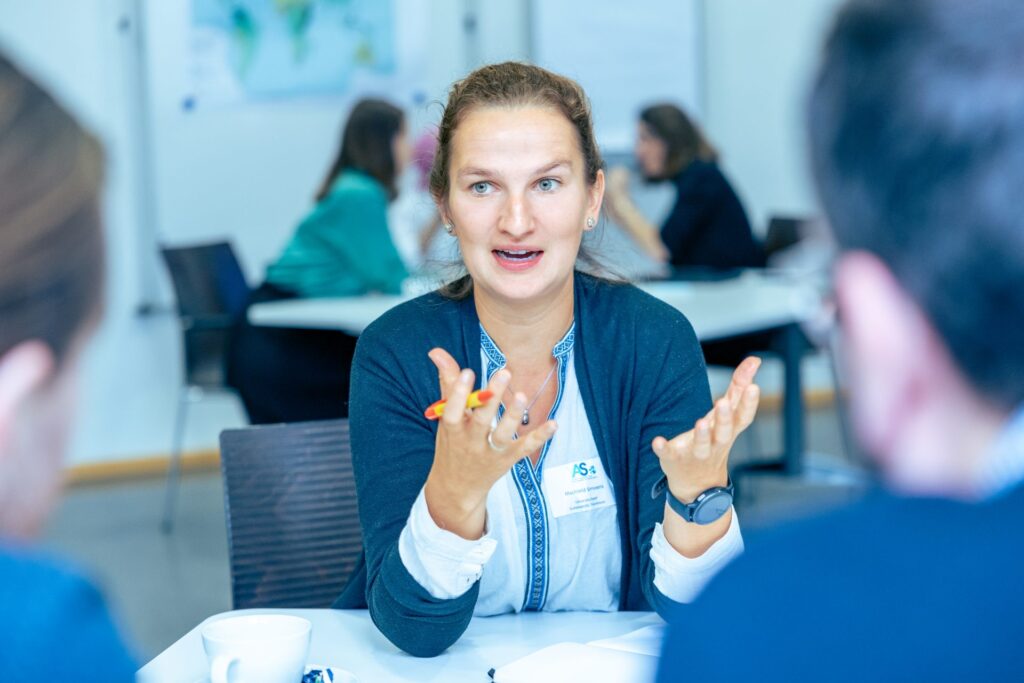 Women speaks with hands up in FRIAS semniar room