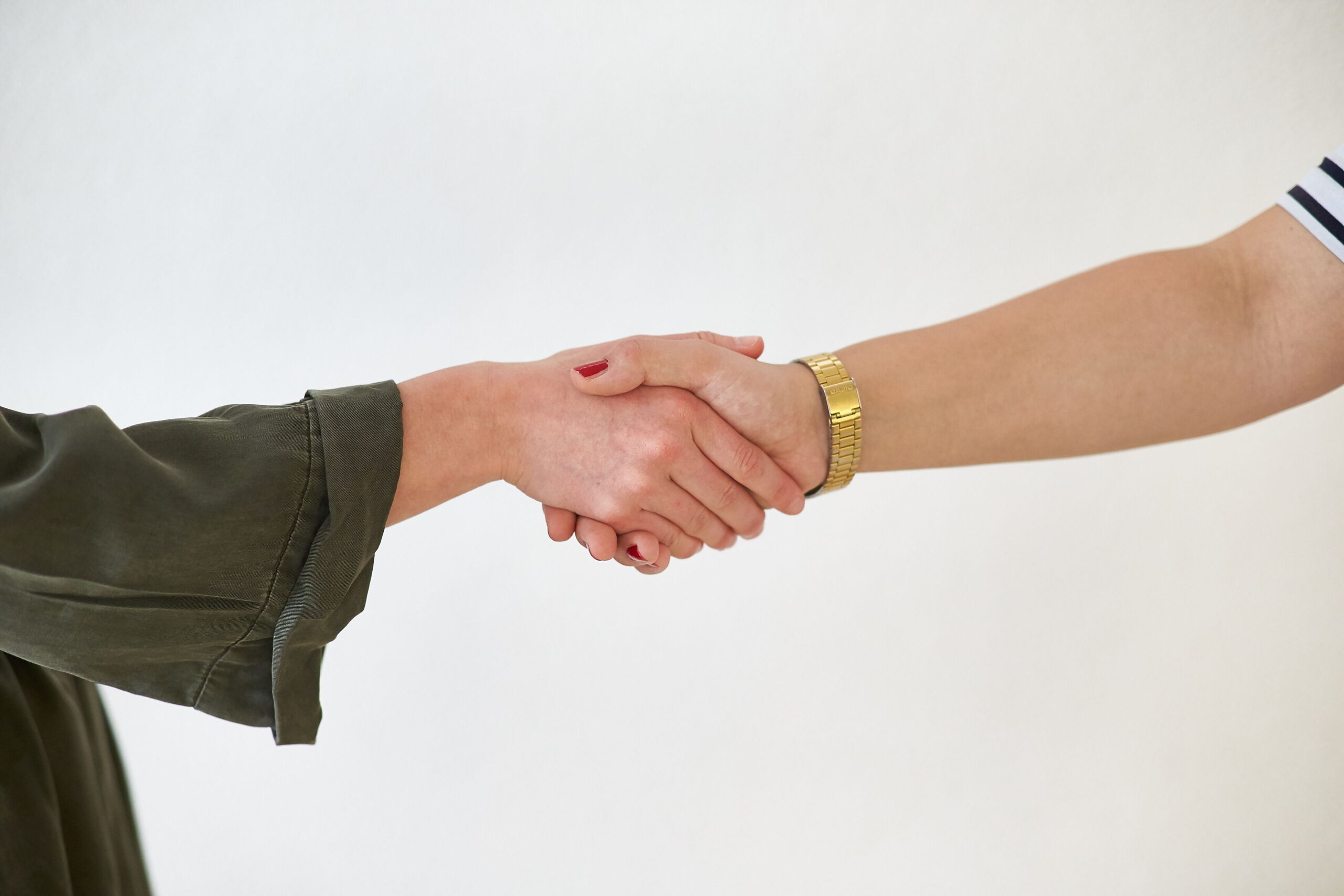 The arms of two people shaking hands.