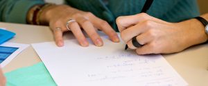 Schreibend: Hände über weißem Blatt mit Stift