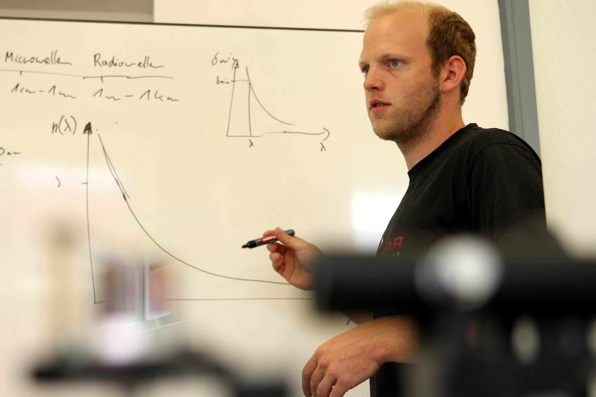 Studierender an Tafel in Übungsgruppe