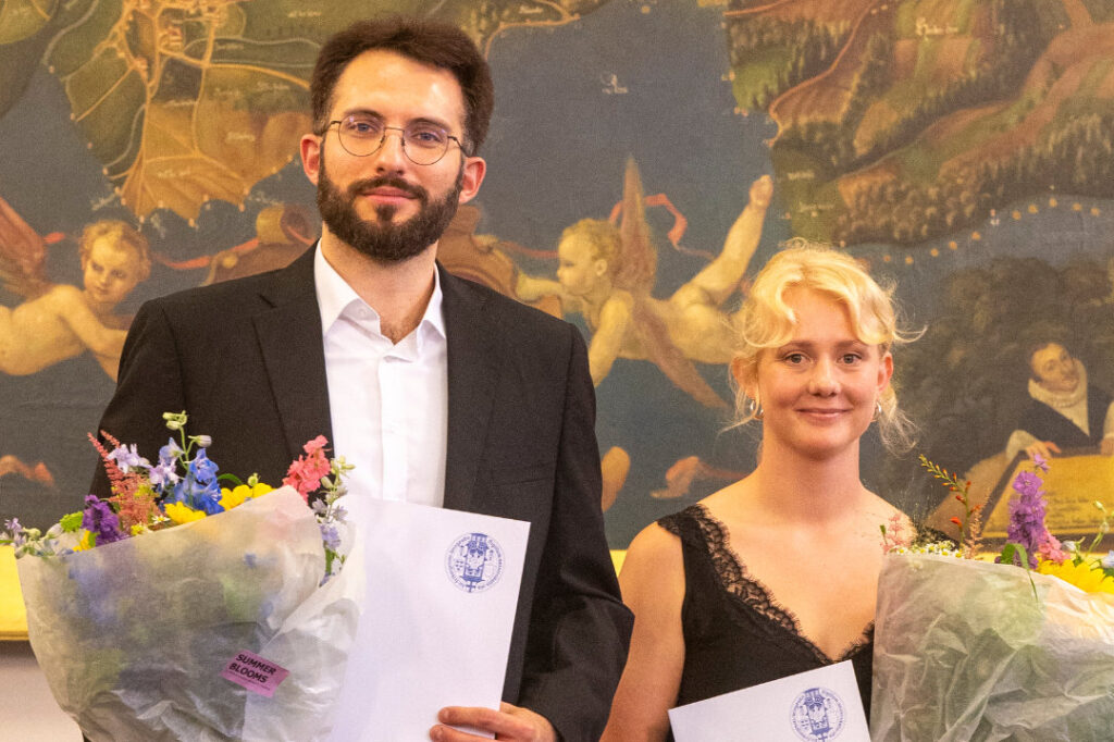 Prize Winners Stefan Conrad und Solveig Degen posing with flowers.