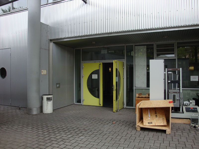 Zwei große gelbe Türen sind zu sehen, von der eine offen steht.