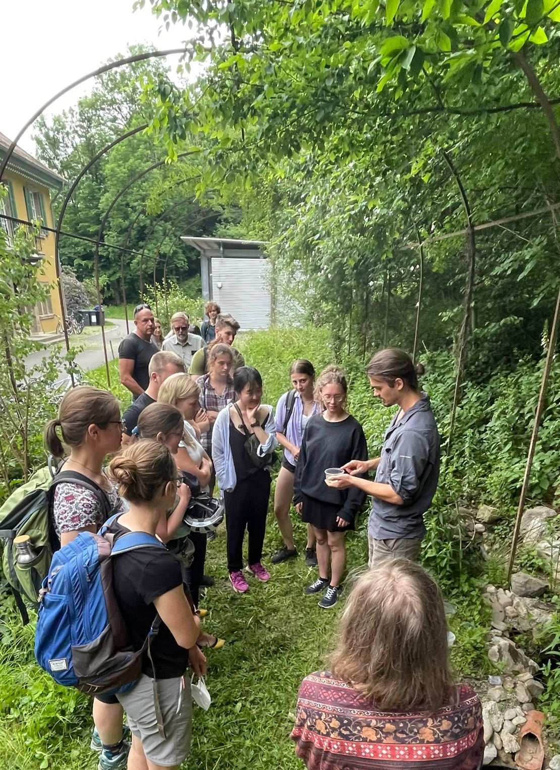 Student zeigt Besucherinnen und Besuchern die Habitate für Amphibien