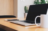 A laptop and a mug on a wooden table