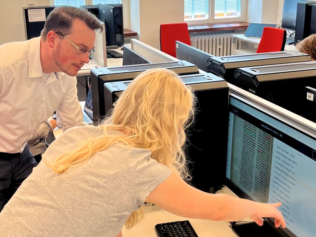 Achim Rabus und Dora Kelemen im Digital Humanities Lab betrachten einen Computerbildschirm.