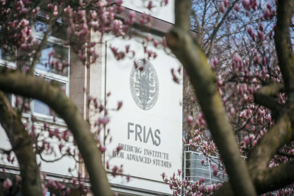 Das Logo auf dem FRIAS-Gebäude zwischen Blüten