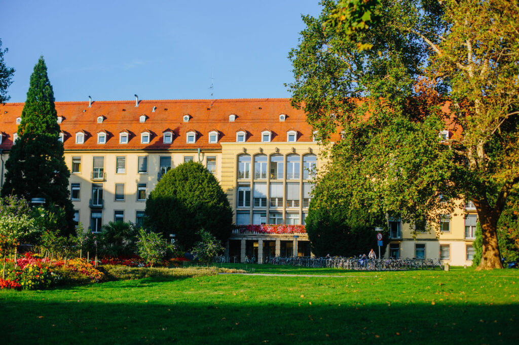 Ein älteres großes Gebäude in einer parkähnlichen Anlage.