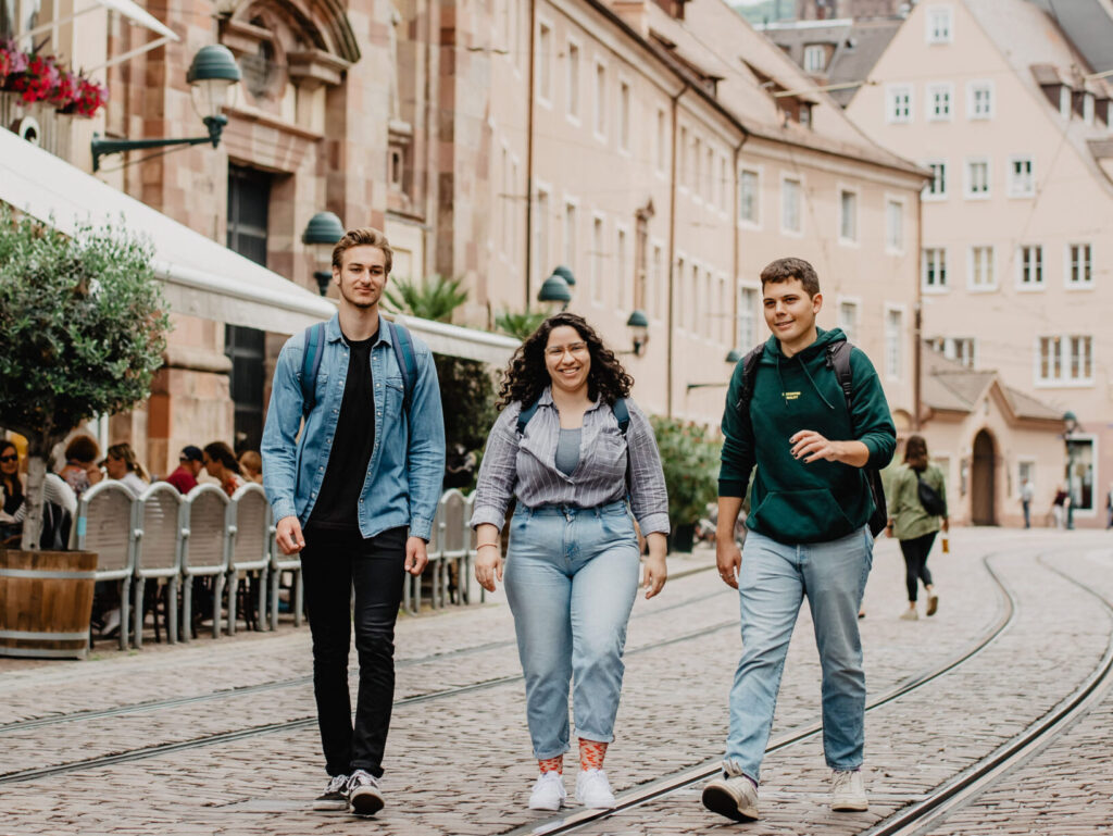 Drei, durch Freiburg laufende, Studierende der Universität Freiburg.