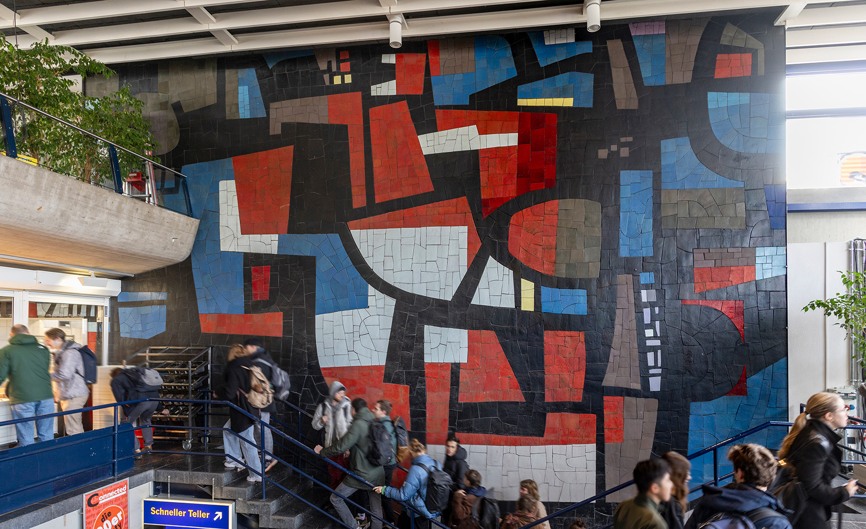 Ein großes dreifarbiges abstraktes Wandmosaik in der Mensa Rempartstraße der Universität Freiburg.
