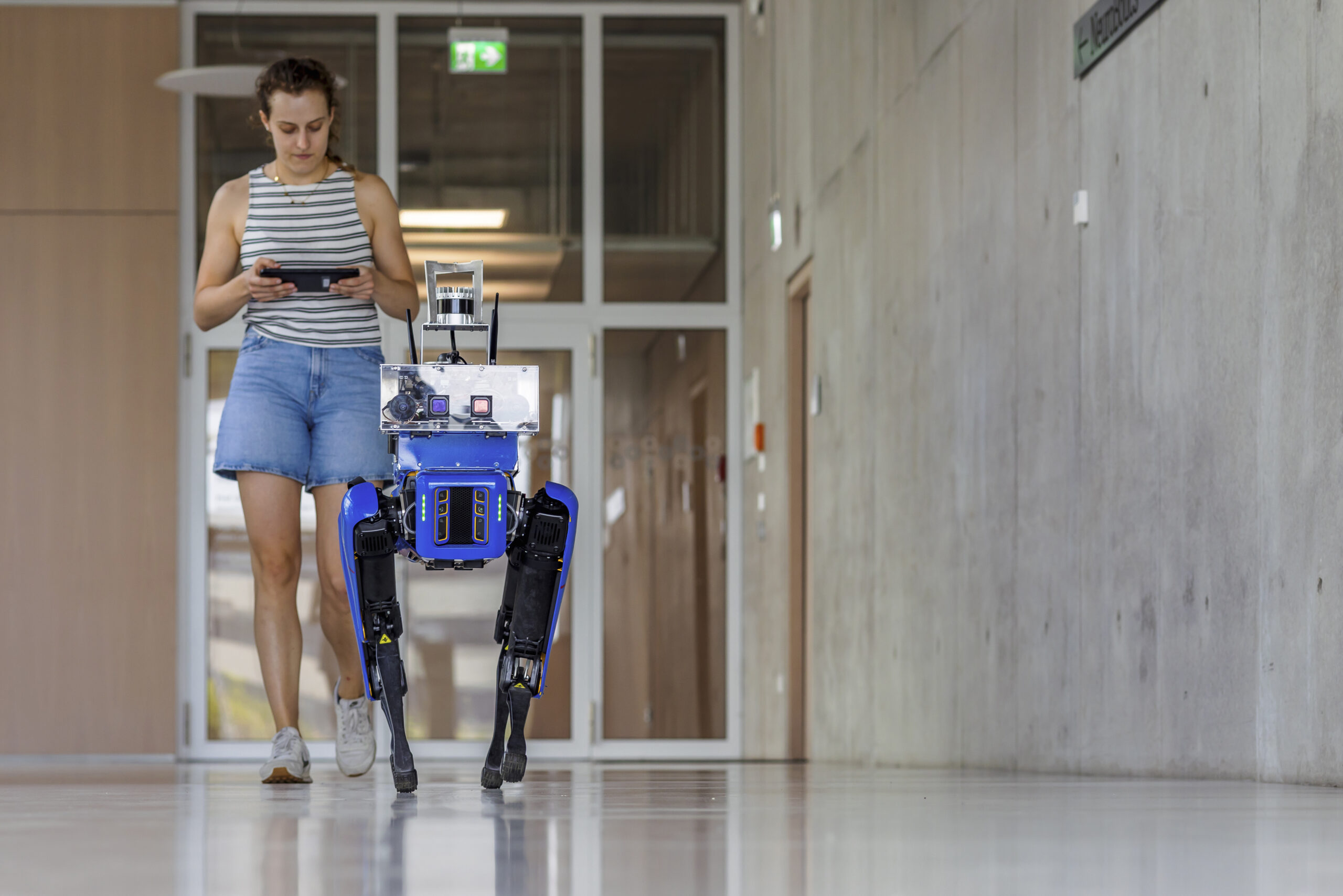 Eine junge Dame steuert einen Roboter fern.