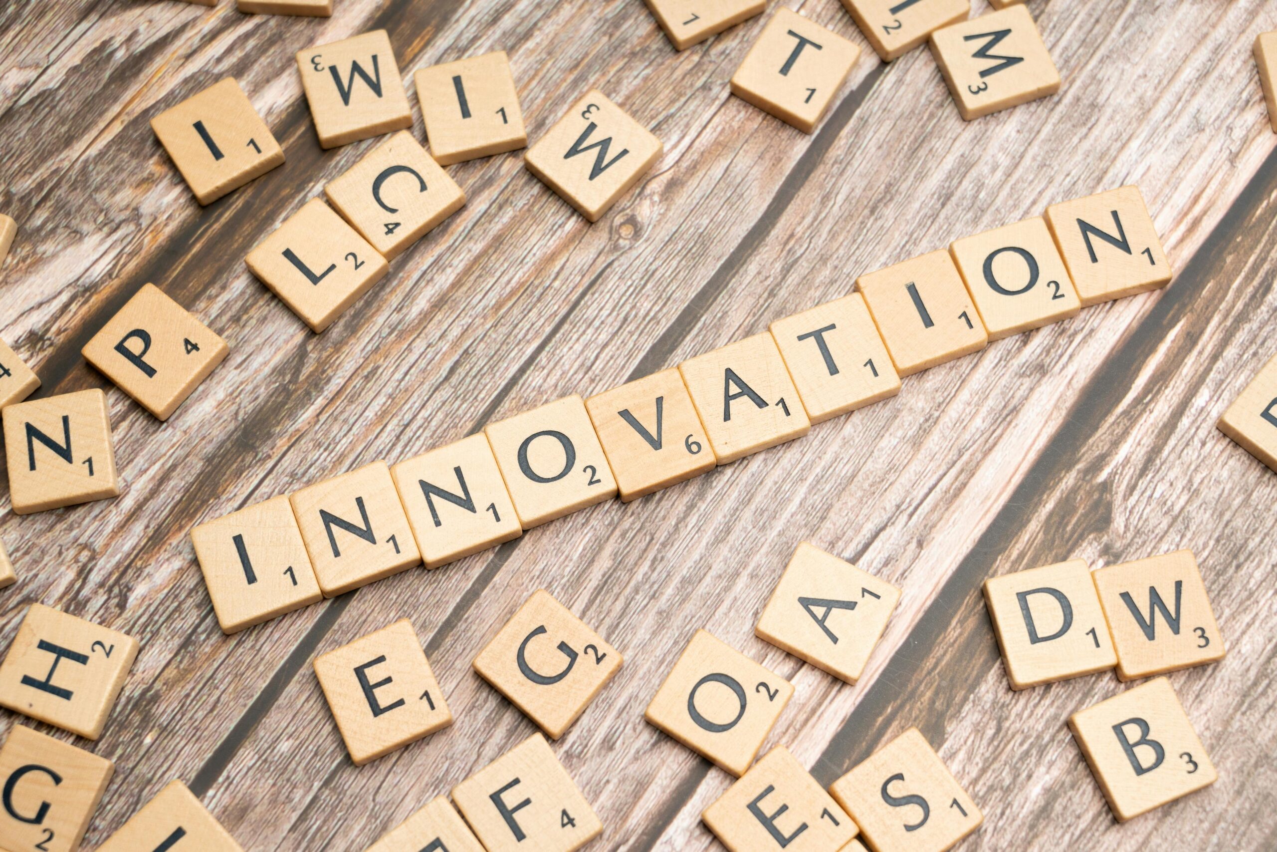 Scrabble-Steine auf Holzbalken die das Wort Innovation bilden